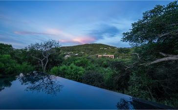 Mountain pool at Amanoi reflecting surrounding landscape at dusk, Vietnam.