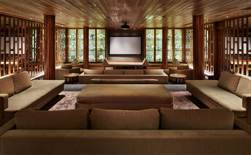 アマンプリのリゾートにある9ベッドルームのオーシャンヴィラの広々としたリビングエリア。木製の格子窓と天井が特徴。