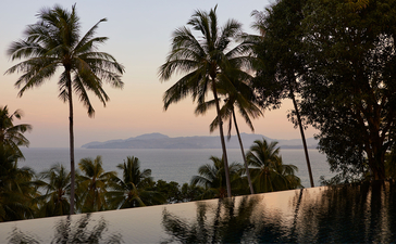 アマンプリのナインベッドルームオーシャンヴィラから見た、夕暮れ時のパルム越しのアンダマン海の眺め。