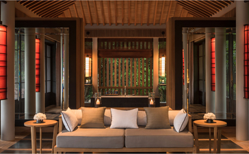 Ocean Pavilion lounge at Amanoi, Vietnam, with wooden ceiling, symmetrical seating and warm lighting.