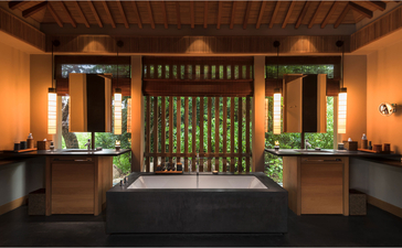 Ocean Pavilion at Amanoi features twin wooden vanities with warm lighting and slatted green screen divider, Vietnam.