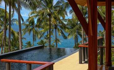 Pavillon au bord de la piscine avec vue sur la mer et les palmiers à Amanpuri.