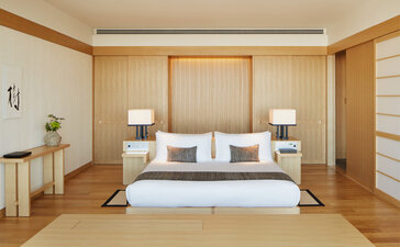 Principal bedroom at Aman Tokyo with wooden panelling, platform bed and shoji screens.