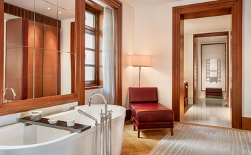 Queen Marija Suite bathroom at Aman Sveti Stefan, with soaking tub, wooden doors and warm lighting.