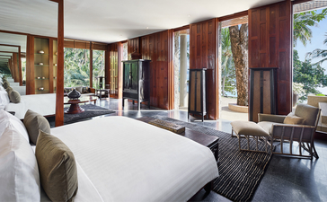 Principal bedroom with burgundy walls and ocean views at Amanpuri resort, Thailand.
