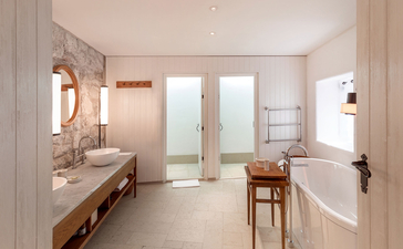 St. Sava Cottage principal bedroom ensuite at Aman Sveti Stefan, Montenegro, with dual vanities and bathtub.