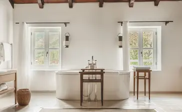 Two-bedroom suite at Aman Sveti Stefan with dual windows, neutral furnishings, and minimalist décor in Montenegro.