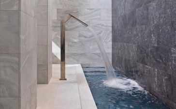 Villa plunge pool at Amanzoe resort, Greece, with minimalist stone surrounds and cascading water feature.