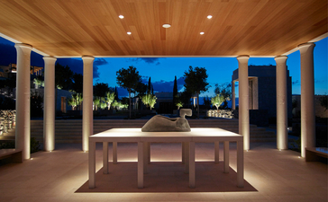 Villa 20 at Amanzoe resort, Greece: open-sided pavilion with stone bath overlooking illuminated gardens at dusk.