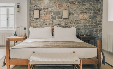 Principal bedroom with stone feature wall at Aman Sveti Stefan, Montenegro.
