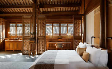Principal bedroom at Amandayan with wooden architectural features and sheer window panels.