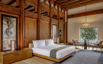 Principal bedroom at Amanyangyun with wooden panelling, platform bed and view to garden terrace.