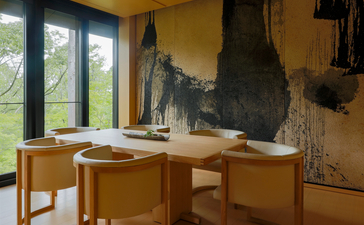 Takagamine Suite dining table at Aman Kyoto resort, with sculptural artwork and garden views through large windows.