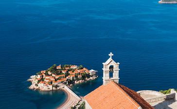 Terracotta-roofed chapel overlooking Aman Sveti Stefan's fortified island and Adriatic Sea.