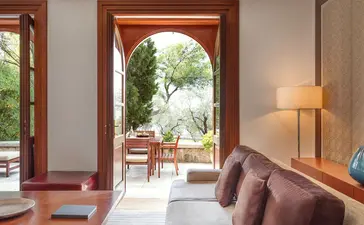 Sitting room at Aman Sveti Stefan with arched doorway opening onto a terrace.