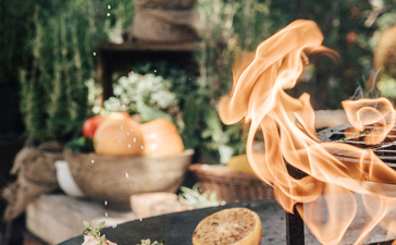 Hand pouring wine over grilled meat at Aman Sveti Stefan.