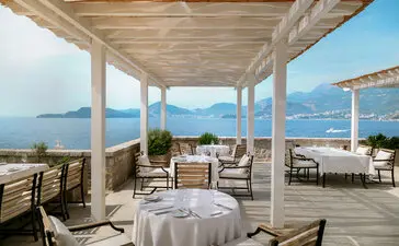 Arva dining venue at Aman Sveti Stefan with Adriatic Sea views from covered terrace.