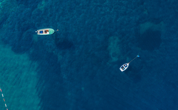 Aerial view of two boats on deep blue Adriatic waters at Aman Sveti Stefan.