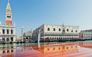 Aman Venice's waterfront location with St Mark's Basilica and the Doge's Palace reflected in the lagoon.