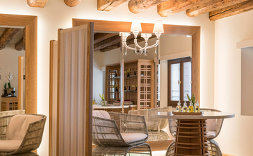 アマン ヴェニスのホテルギャラリー。露出した梁のある明るい空間に、木製の家具と照明が配置されている。