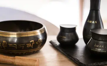 安缦威尼斯酒店画廊内,木质表面上摆放着黑色陶瓷容器和香薰瓶。