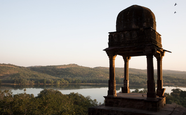 A stone pavilion with a domed roof overlooks a river valley at Aman-i-Khas, with forested hills beyond.