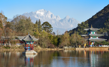 Amandayan's riverside setting with traditional wooden boat and mountain views reflected in calm water.
