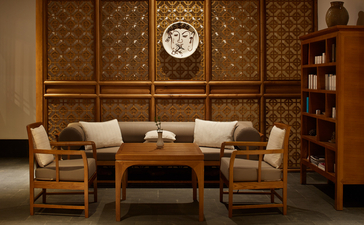 Wellness lounge at Amandayan with wooden panelled walls, comfortable seating, and a central clock.