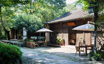 Dining pavilion at Amanfayun with timber roof and open-air seating amongst verdant gardens.