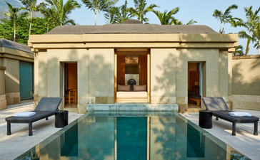 Spa pavilion with plunge pool at Amanjiwo, flanked by loungers beneath palm trees.