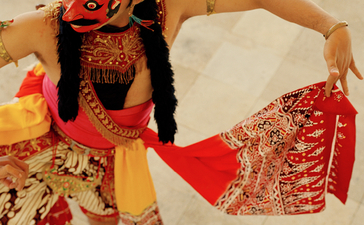 Wayang kulit puppet in traditional red and gold costume displayed on marble floor at Amanjiwo resort.