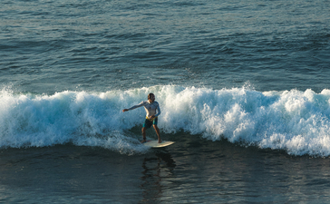 Surfer riding a wave at Amankila, Bali.