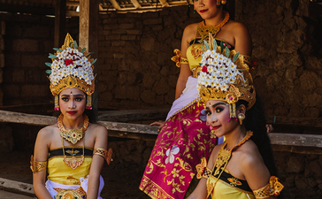 Balinese statues adorned with pink flowers and gold leaf at Amankila resort.