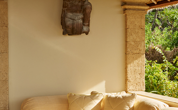 Wooden sculpture displayed above a sunlit spa bath at Amankila resort.