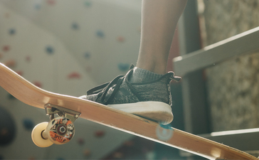 Grüner Papagei sitzt auf einem Ast im Amanpuri Resort.