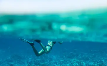 Scuba diver exploring the underwater terrain at Amanwana Dive Centre.