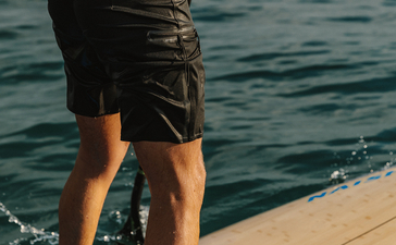 安缦湾澜度假村，客人站在水上平台边缘，面向大海。