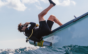 宾客在安缦湾澜度假村享受水上运动，从蓝色平台跳入清澈海水。