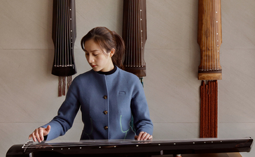 Child playing guzheng, a traditional Chinese stringed instrument, at Amanyangyun.