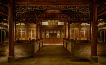 Illuminated traditional pavilion at Amanyangyun, with symmetrical wooden doors and warm lighting at dusk.