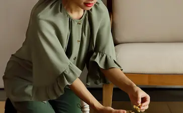 Woman arranging flowers in a wooden bowl at Amanyangyun.