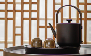 Tea service with black teapot and cups on round table at Amanyangyun.