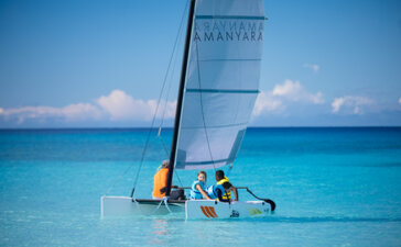 Familia navegando en catamarán en aguas turquesas en Amanyara, centro vacacional.