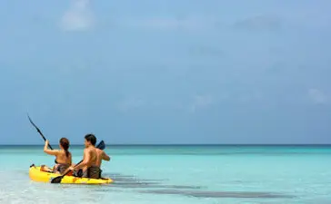 Familia disfrutando de actividades acuáticas en las aguas turquesas de Amanyara.