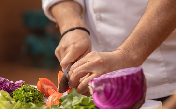 Chef's hands slicing purple cabbage at Aman Villas at Nusa Dua.