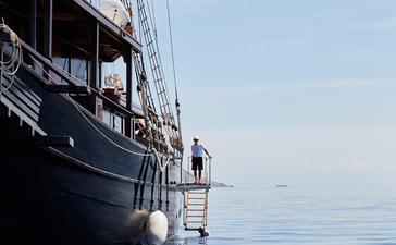 Exterior view of Amandira's vessel moored in calm blue waters.