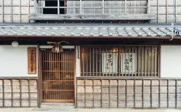 Amanemu's traditional Japanese façade with wooden doors and latticed windows beneath a dark tiled roof.