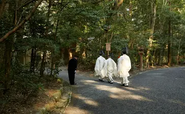 宾客漫步在安缦伊沐度假村林间小径上，阳光透过树叶洒下斑驳光影。