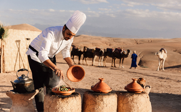 アマンジェナ リゾートで、家族向け体験として、砂漠でラクダの世話をする子どもたち。