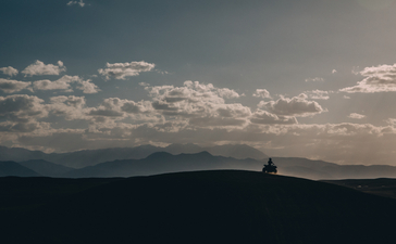 安缦珍纳度假村上空的晴朗天空，远处山峦轮廓清晰。